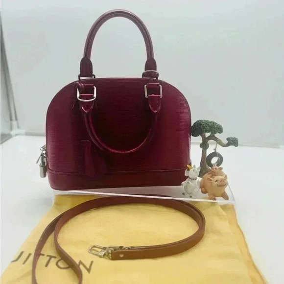 Louis Vuitton's Epi Alma BB in striking fuchsia, featuring silver-tone hardware - Picture 2 of 6